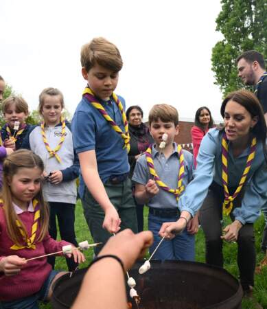 La princesse Charlotte, le prince George, le prince Louis et Kate Middleton faisant cuire des marshmallows après avoir pris part aux rénovations d'un camp scout dans le Berkshire pour le Big Help Out.