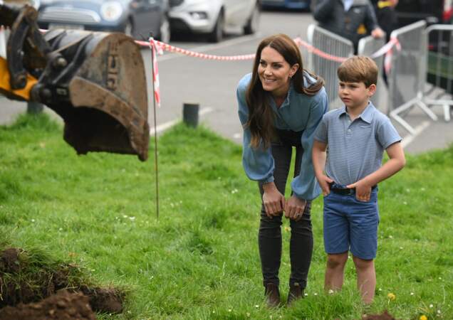 Kate Middleton et le prince Louis observant les autres volontaires à l'oeuvre pour la rénovation d'un camp scout à Slough pour la journée du Big Help Out.