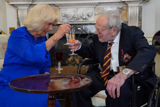Camilla Parker Bowles, reine d'Angleterre, assise aux côtés de Michael de Burgh, vétéran de la Seconde Guerre, lors d'une réception organisée à Clarence House à Londres, ce jeudi 8 juin 2023. 