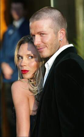 David et Victoria Beckham prennent la pose devant les photographes à Londres en 2004. La styliste porte une belle bouche rouge