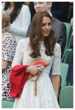 La petite robe blanche brodée de Kate Middleton au tournoi de tennis de Wimbledon, le 2 juillet 2014. Elle accessoirise son look signé Zimmermann d'une petite pochette en raphia multicolore. 