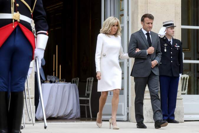 Brigitte Macron choisit une élégante robe immaculée à manches longues associée à une paire d'escarpins pointus beiges pour accueillir le président de la République de Corée, le 20 juin 2023