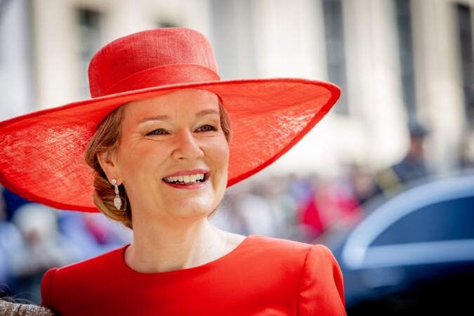 La reine Mathilde éblouissante dans une robe rouge écarlate, le jour de la Fête nationale, à Bruxelles, le 21 juillet 2023.