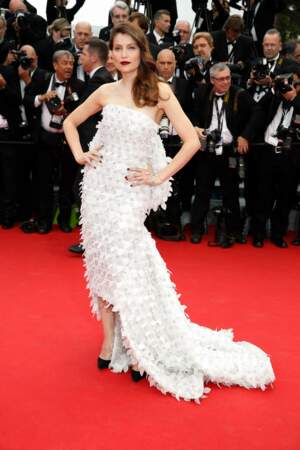 Laetitia Casta se love d'une robe blanche à longue traîne Dior lors du Festival de Cannes, le 14 mai 2014