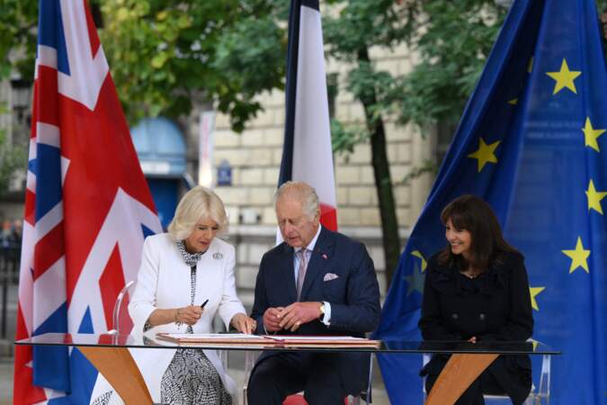 La reine Camilla, le roi Charles III et la maire de Paris Anne Hidalgo signent un livre d'or lors de leur visite du marché aux fleurs reine Élizabeth II de Paris, ce jeudi 21 septembre 2023