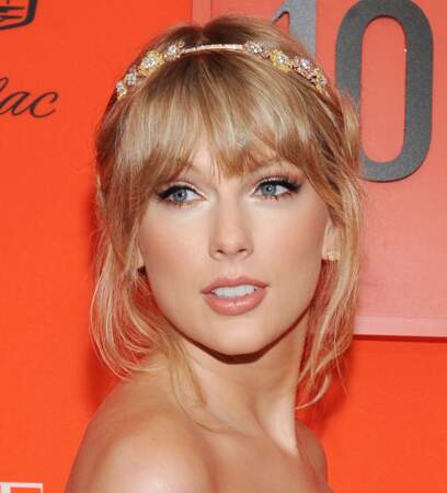 Sur le tapis rouge, Taylor Swift craque pour les accessoires comme ici avec ce beau head band qu'elle place juste au dessus de sa frange. 