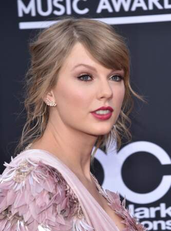 Fin de sa période blond platine, à la soirée Billboard Music awards au MGM Grand Garden Arena à Las Vegas en 2018, Taylor Swift renoue avec son blond cendré et affiche un chignon flou romantique. 