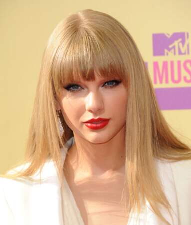 En 2012, pour la cérémonie des MTV VIDEO MUSIC AWARDS à Los Angeles, Taylor Swift affiche un joli blond cendré avec un maquillage soutenu, le regard ourlé et la bouche rouge incendiaire. 