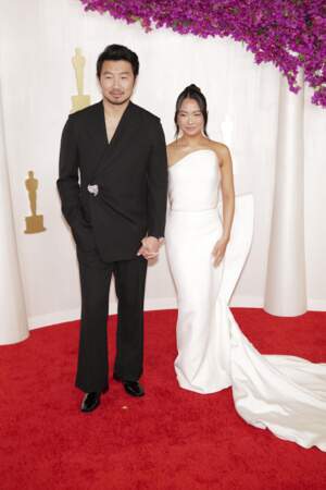 Simu Liu et sa compagne  Allison Hsu en robe bustier blanche à la 96ème cérémonie des Oscars le 10 mars 2024