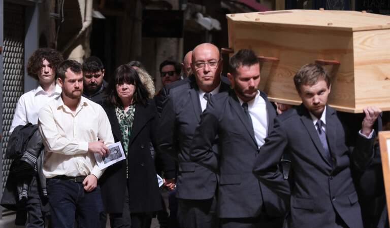 Sa famille se tient derrière le cercueil 
