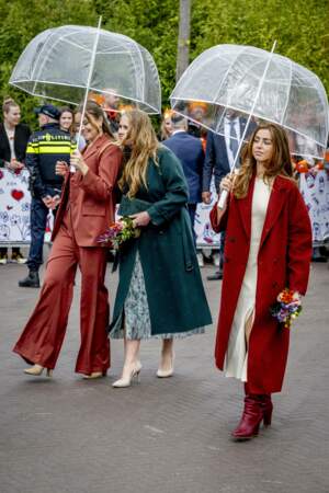 Les princesses Catharina-Amalia, Alexia et Ariane des Pays-Bas, sous des parapluies, lors de la 11ᵉ Fête du Roi 2024 à Emmen, province de Drenthe, le 27 avril 2024