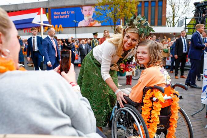 La reine Maxima des Pays-Bas se prend au jeu des selfies, lors de la 11ᵉ Fête du Roi 2024 à Emmen, province de Drenthe, le 27 avril 2024