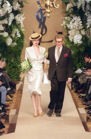 Laetitia Casta clôture pour la dernière fois un défilé Yves Saint Laurent en compagnie du couturier, lors du défilé Haute Couture 2002, qui rend hommage au Paris des années 1950