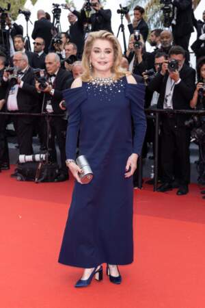 Catherine Deneuve vêtue d'une somptueuse robe bleu marine ornée de cristaux, Louis Vuitton, lors de la montée des marches du film “Jeanne du Barry” pour la cérémonie d’ouverture du 76ᵉ Festival de Cannes, le 16 mai 2023