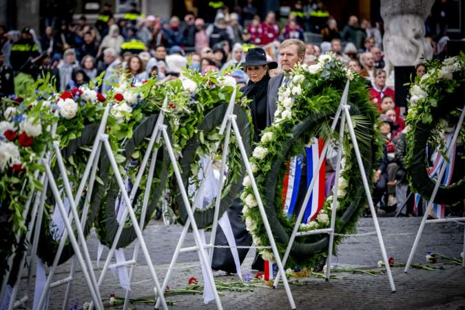 Le roi Willem-Alexander et la reine Maxima des Pays-Bas derrière des couronnes de fleurs de la Journée commémorative nationale 2024, à Amsterdam