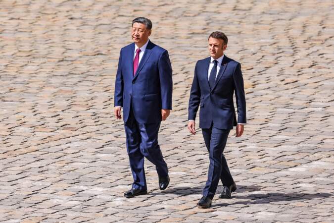 Le président Emmanuel Macron marche aux côtés du président Xi Jinping lors de la cérémonie d'accueil officiel à l'Hôtel national des Invalides à Paris, le 6 mai 2024.