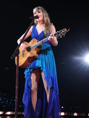 Taylor Swift chante à Paris dans une  une robe en mousseline de soie à motif ombré dans les tons bleus signée Roberto Cavalli