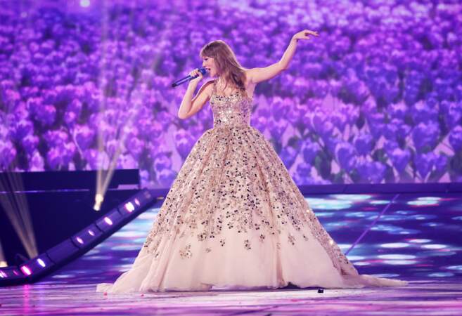 Taylor Swift dans une longue robe bouffante couleur lila ornée de pierres, de paillettes et de cristaux