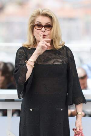 Catherine Deneuve malicieuse devant les photographes au Festival de Cannes, le 22 mai 2024