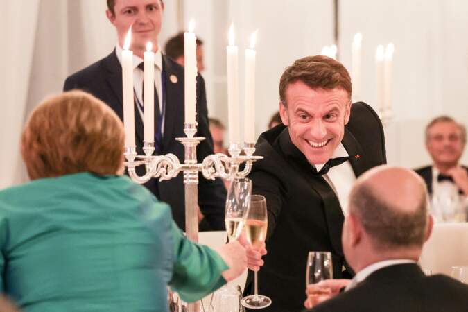 Emmanuel Macron trinque avec Angela Markel lors d'un diner d'état, au château de Bellevue, en Allemagne, le 26 mai 2024