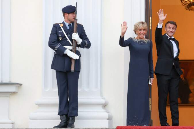 Emmanuel Macron et Brigitte Macron saluent l'assistance lors d'un diner d'état, au château de Bellevue, lors une visite d'État de trois jours en Allemagne, le 26 mai 2024