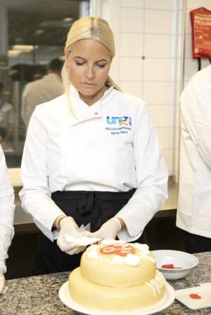 La princesse Mette-Marit de Norvège en pleine confection d'un gâteau à l'occasion du 20ᵉ anniversaire de la fondation Kronprinparets à Modum, le 13 octobre 2021