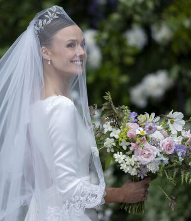 Olivia Henson a complété sa robe de mariée avec un bouquet champêtre composé de marguerites, d'iris, de roses ou encore de clématite