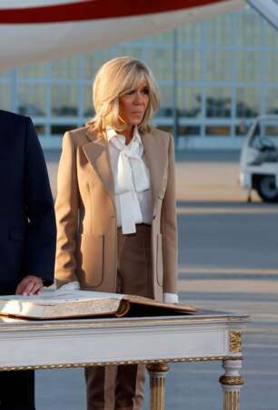 Brigitte Macron en look beige et chemisier lavallière à l'aéroport Franz Josef Strauss de Munich, à la veille du sommet du G7, le 25 juin 2022