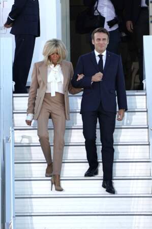 Brigitte Macron en look beige, escarpins et chemisier lavallière à sa descente de l'avion avec Emmanuel Macron à Munich, à la veille du sommet du G7, le 25 juin 2022