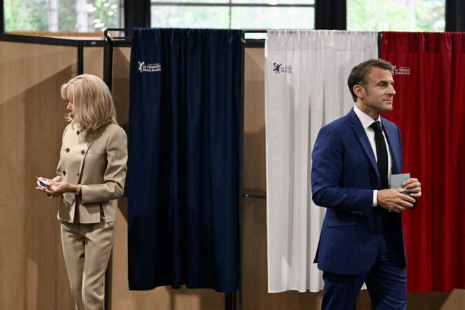 Emmanuel et Brigitte Macron sortent de l'isoloir pour le premier tour des législatives à la salle des Quatre Saisons au Touquet, le 30 juin 2024