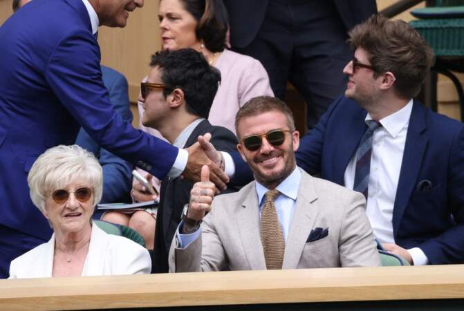 Lunettes de soleil sur le nez, habillée d’un costume blanc, la mère de David Beckham, Sandra, a suivi son fils dans les tribunes, lundi 1ᵉʳ juillet à Londres. 