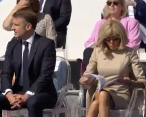 Brigitte Macron porte une robe beige ainsi qu'une paire de lunettes de soleil lors du défilé du 14 juillet 2024.