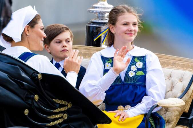 La princesse Estelle, 12 ans, et son petit frère, le prince Oscar, 8 ans, saluant la foule lors de la parade à Stockholm. 6 juin 2024. 
